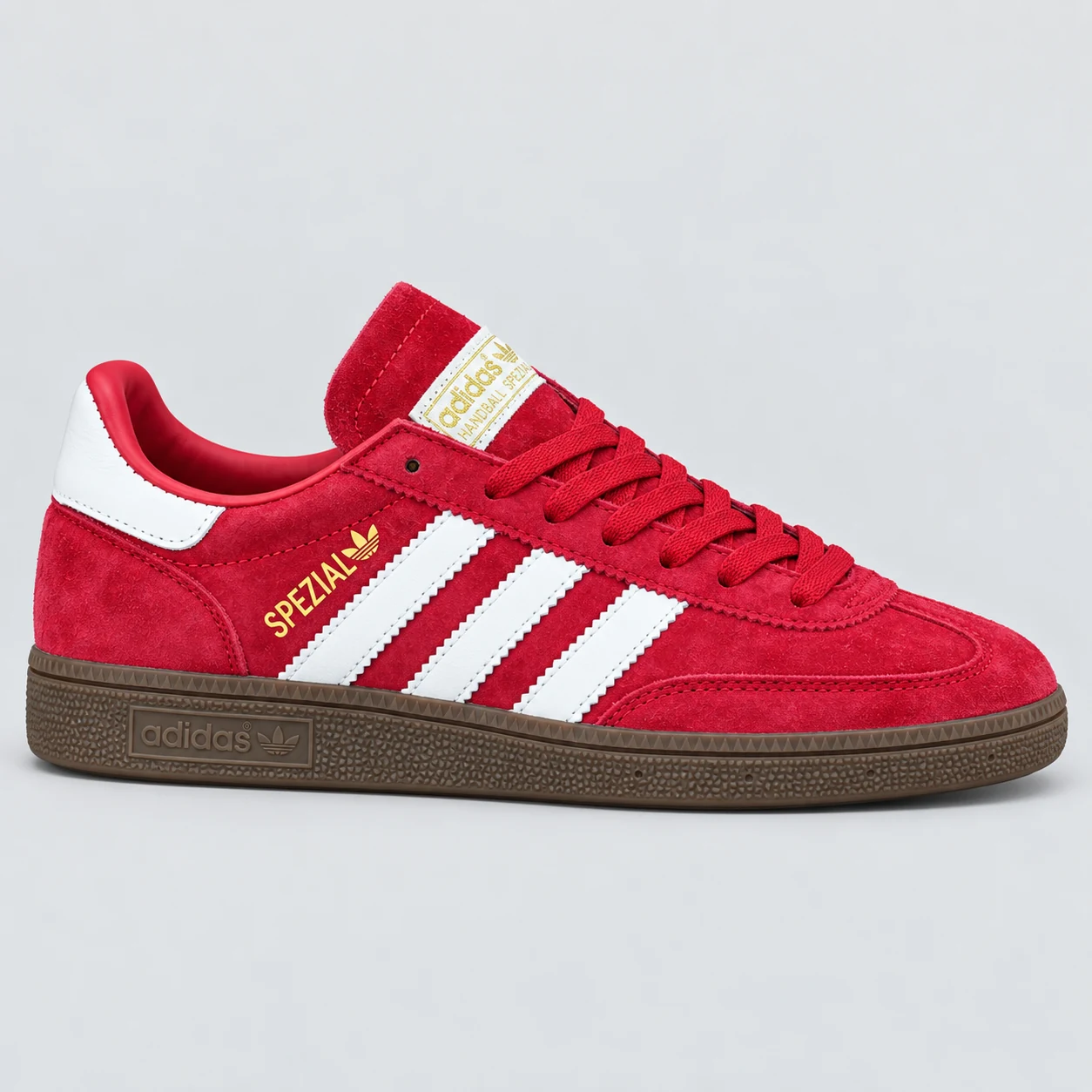 adidas Handball Spezial — Red / White / Brown Red / White / Brown low-top sneaker with lace-up fastening, layered panels and three-stripe detailing. Browse the cleaned catalogue image and original supplier photo, and select your UK size from 3 to 9.