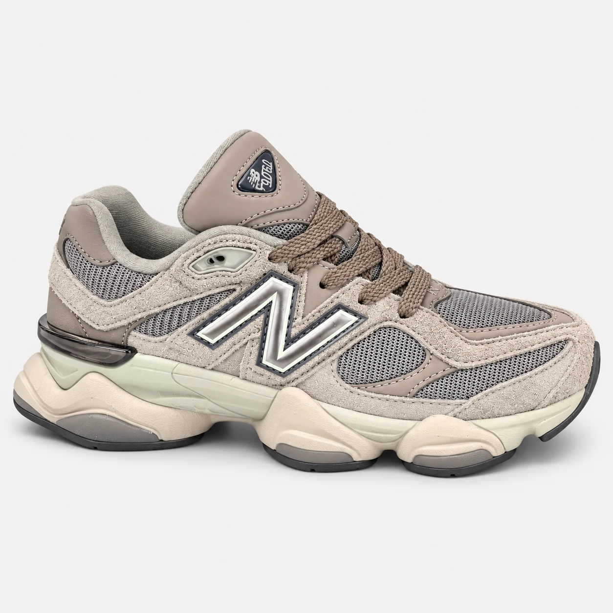 New Balance 9060 — Taupe / Grey / Cream Taupe / Grey / Cream low-top sneaker with lace-up fastening, layered panels and visible N branding. Browse both the cleaned catalogue image and original supplier photo, and select your UK size from 3 to 9.
