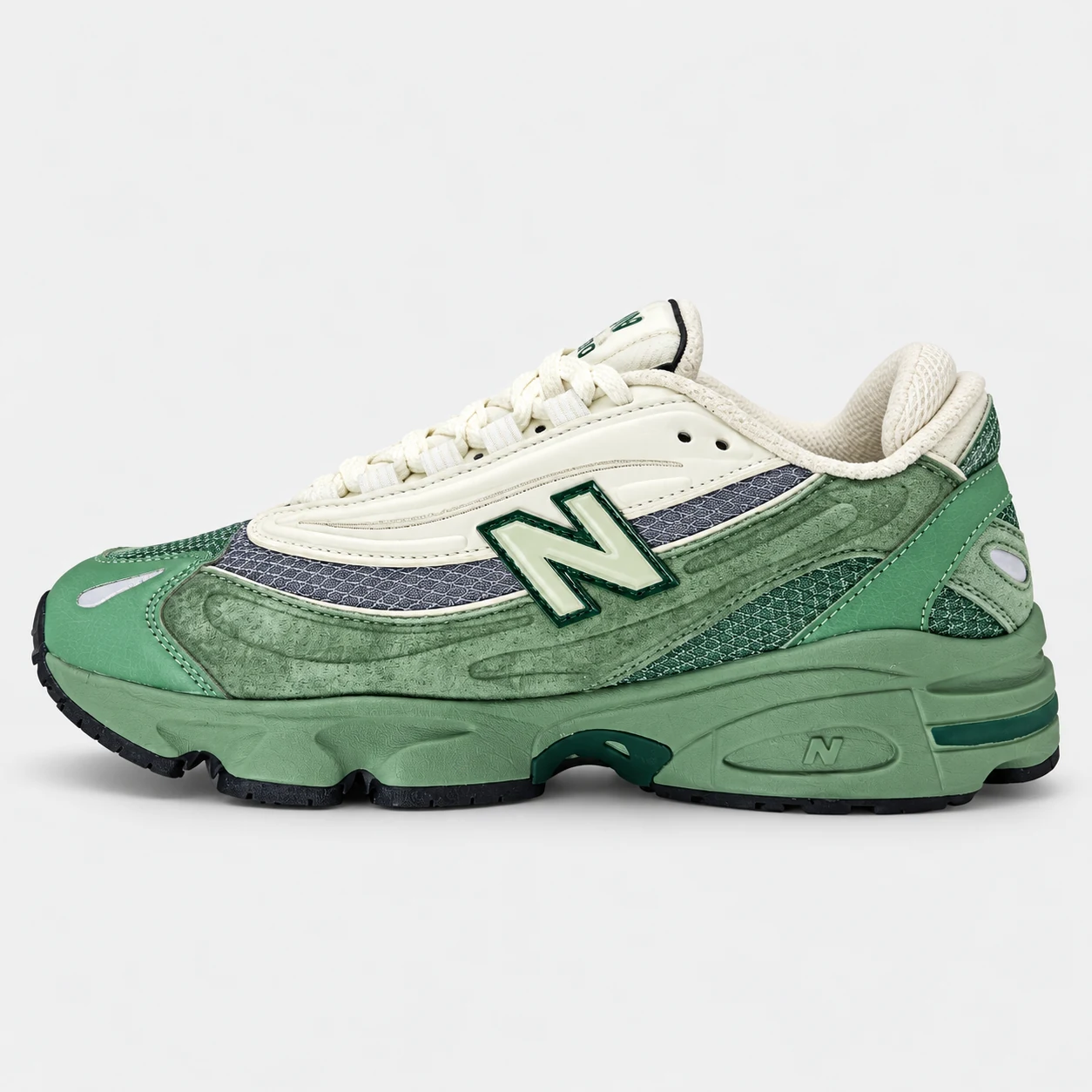 New Balance 1000 — Green / Cream / Grey Green / Cream / Grey low-top sneaker with lace-up fastening, layered panels and visible N branding. Browse both the cleaned catalogue image and original supplier photo, and select your UK size from 3 to 9.