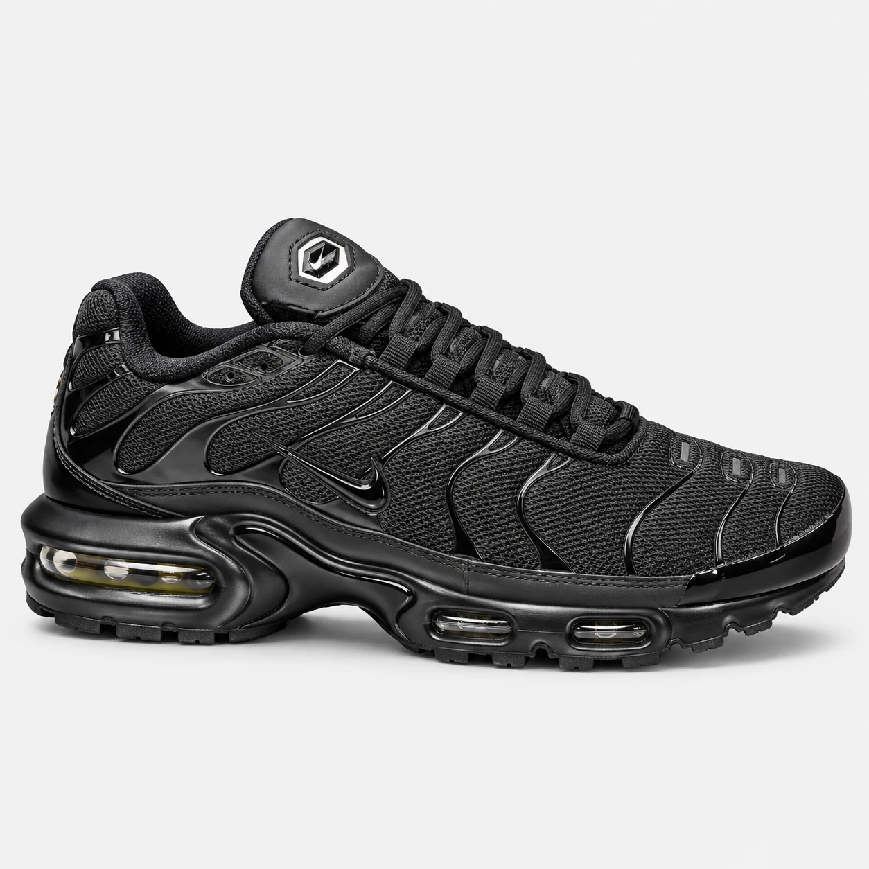 Nike Air Max Plus — Black Black low-top sneaker with lace-up fastening, layered panels and visible Swoosh branding. Browse the cleaned catalogue image and original supplier photo, and select your UK size from 3 to 9.