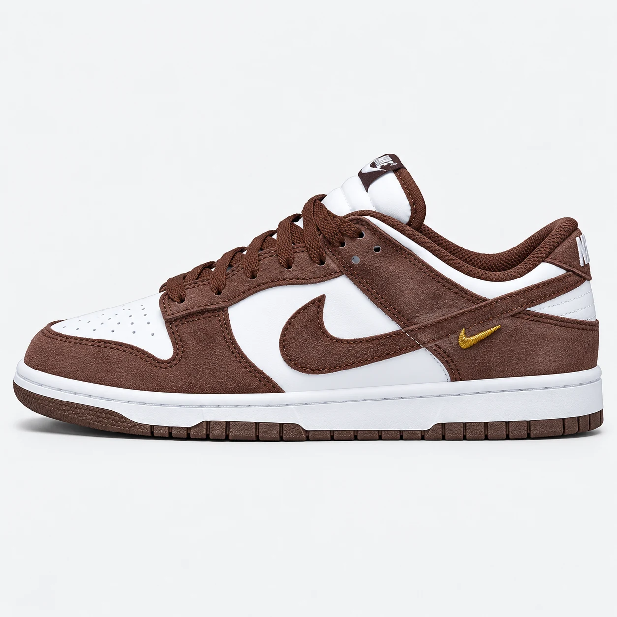 Nike Dunk Low — Brown / White / Gold Brown / White / Gold low-top sneaker with lace-up fastening, layered panels and visible Swoosh branding. Browse the cleaned catalogue image and original supplier photo, and select your UK size from 3 to 9.