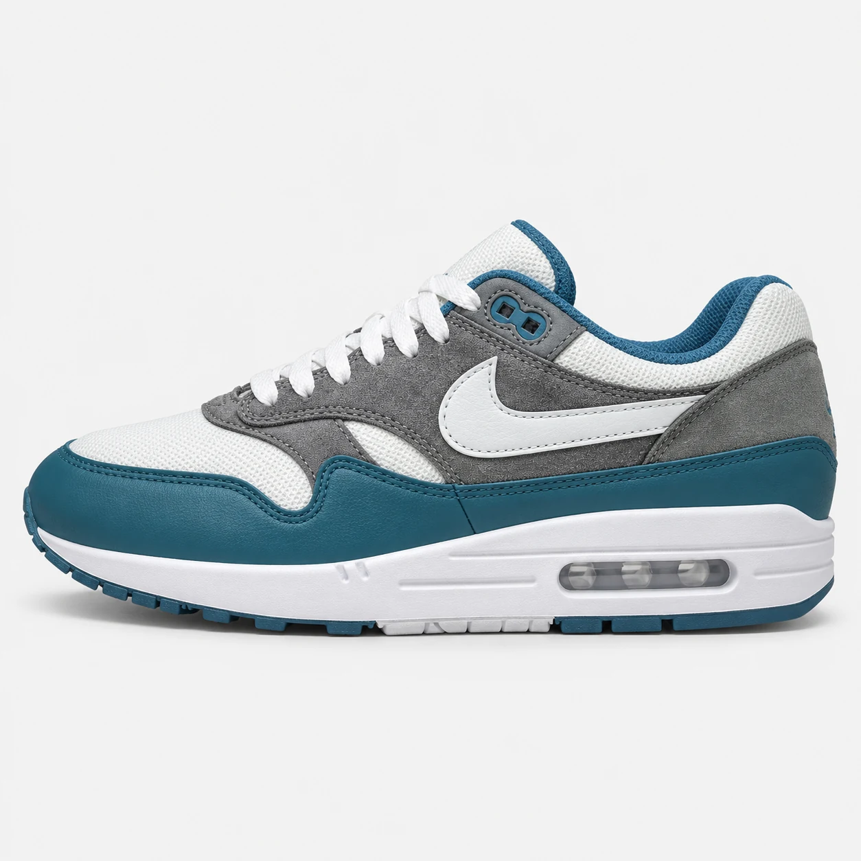 Nike Air Max 1 — White / Grey / Teal White / Grey / Teal low-top sneaker with lace-up fastening, layered panels and visible Swoosh branding. Browse the cleaned catalogue image and original supplier photo, and select your UK size from 3 to 9.