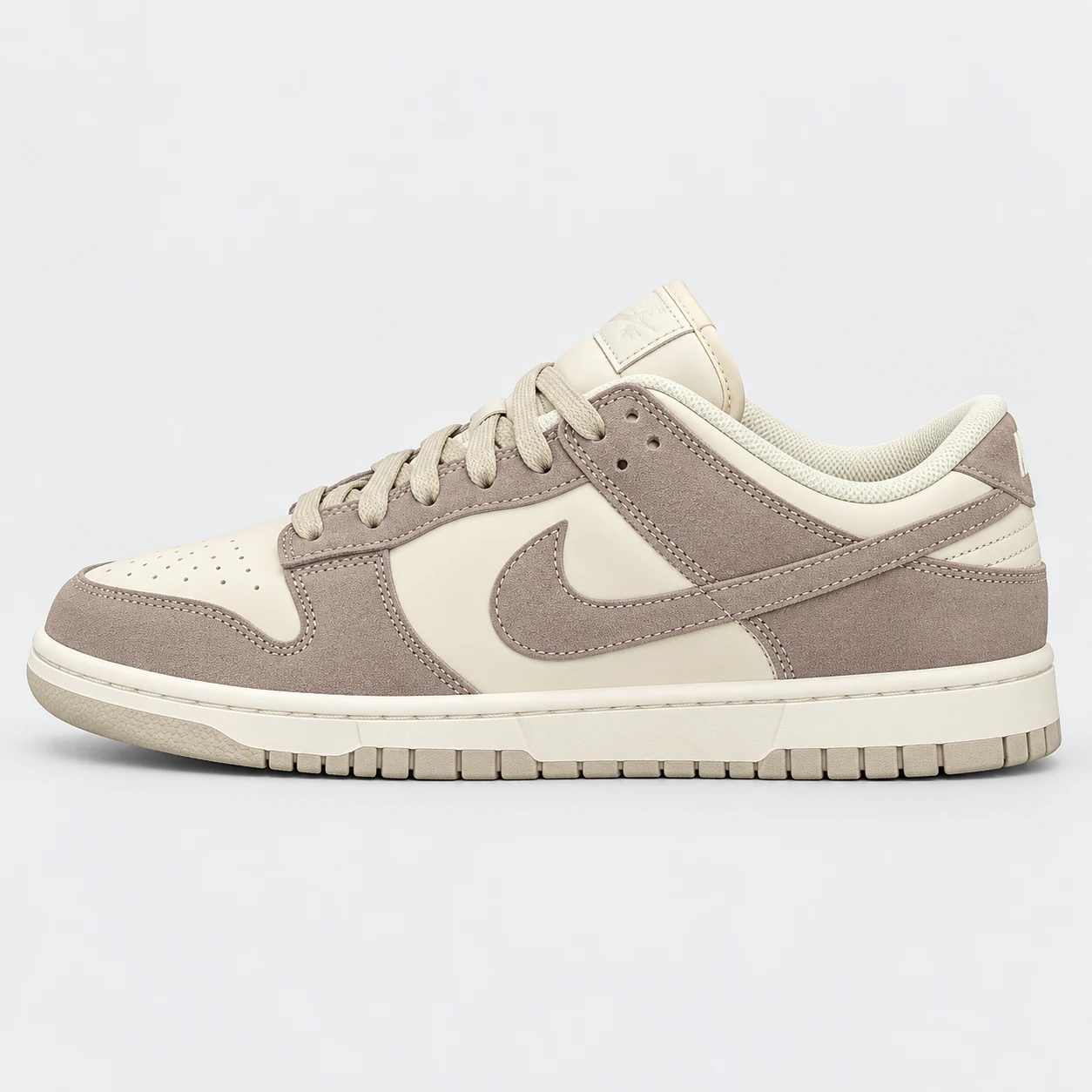 Nike Dunk Low — Taupe / Cream Taupe / Cream low-top sneaker with lace-up fastening, layered panels and visible Swoosh branding. Browse the cleaned catalogue image and original supplier photo, and select your UK size from 3 to 9.