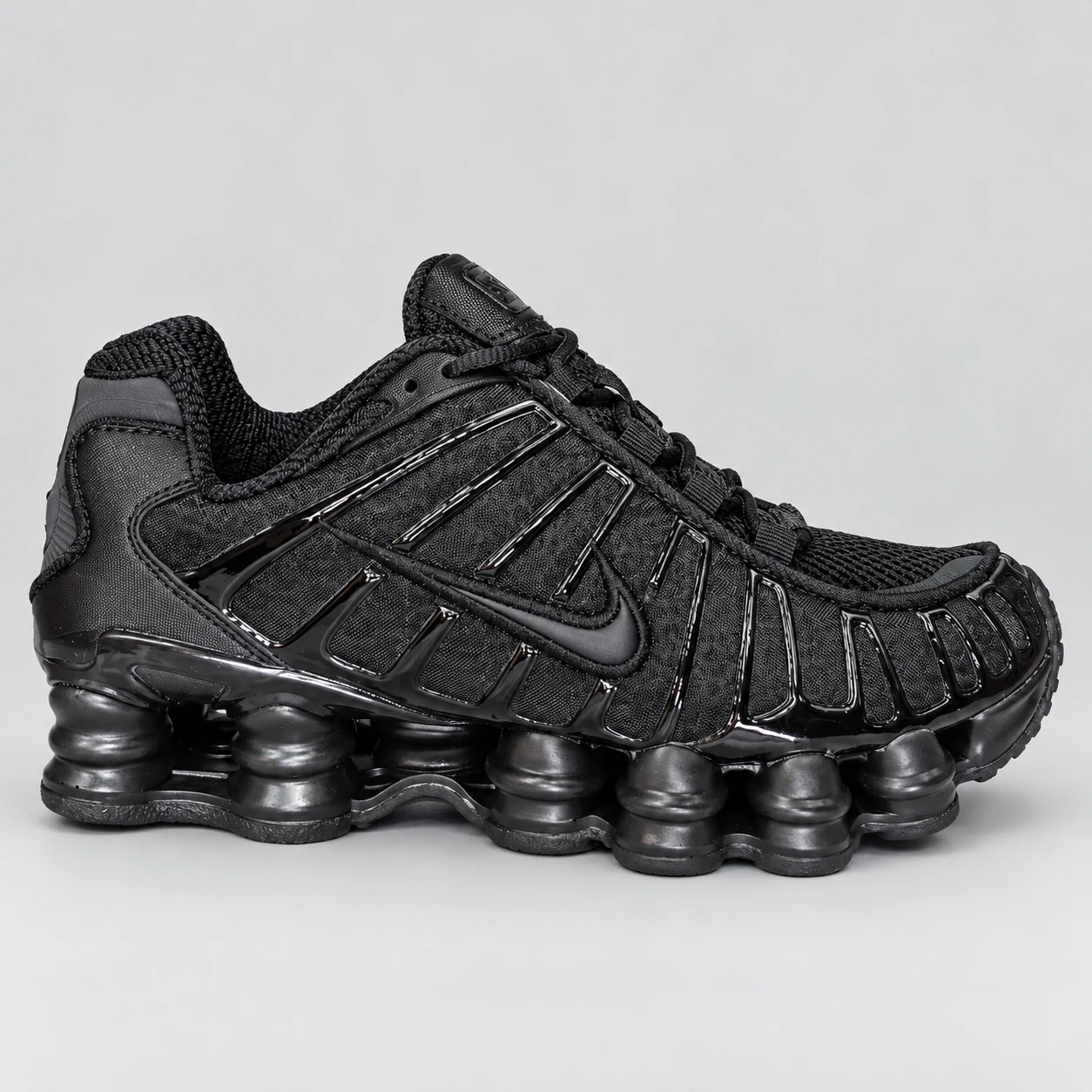 Nike Shox TL — Black An all-black low-top sneaker with a ribbed side cage, lace-up fastening and a sculpted column-style sole. Choose a UK size from 3 to 9 and view the product photos at The Drip Society.